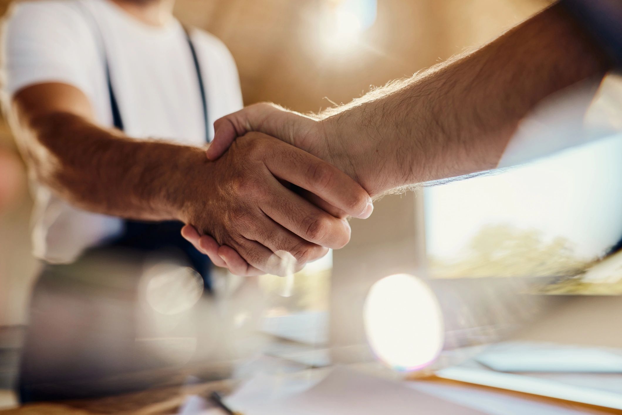 Two professionals shaking hands to finalize an agreement.