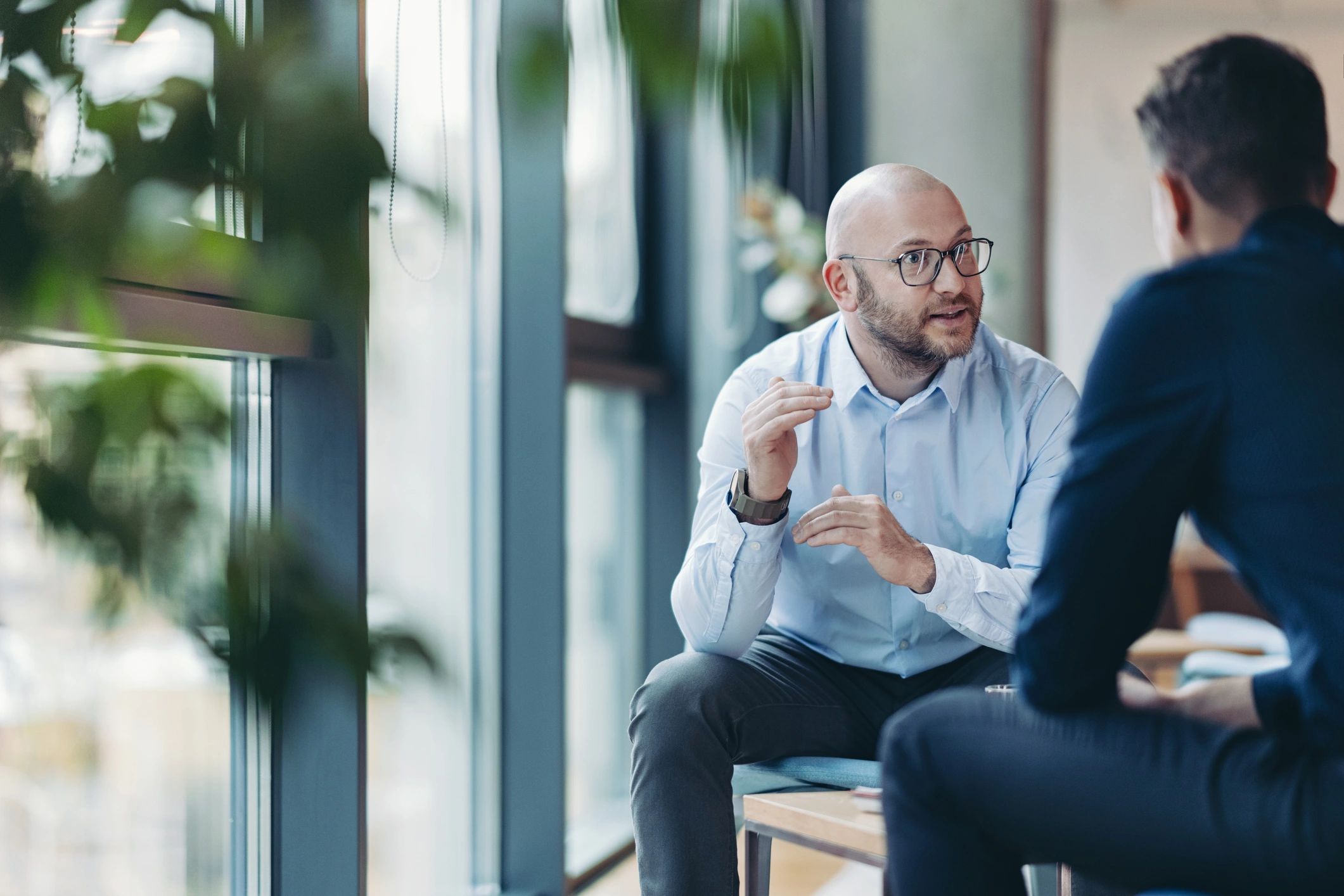 Two professionals discussing leadership coaching in an office
